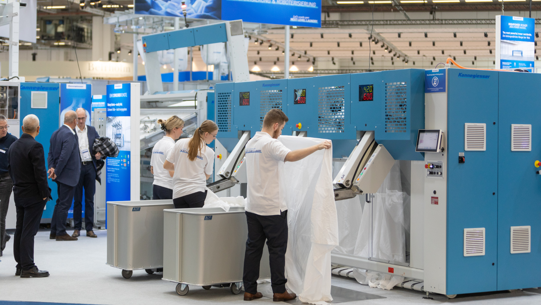 Exhibitors demonstrate an industrial textile processing machine at Texcare