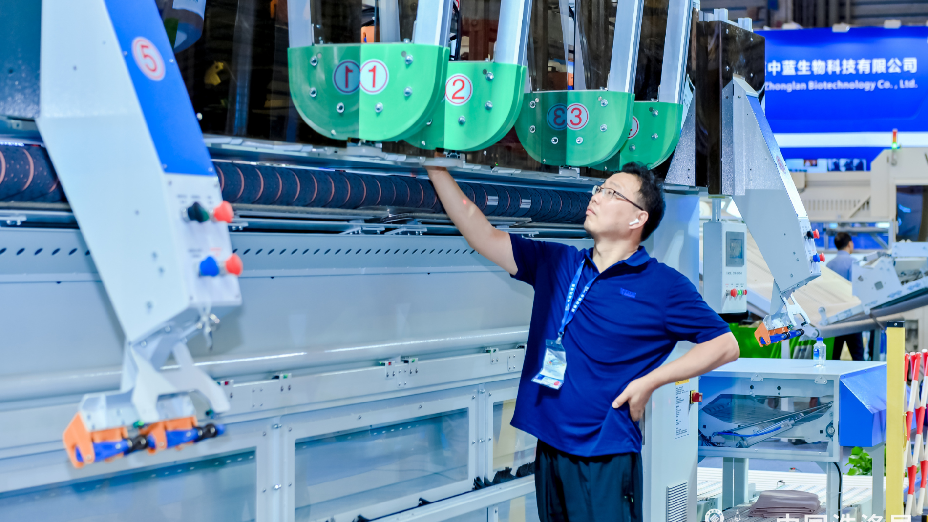 Ein Aussteller steht vor einer Maschine