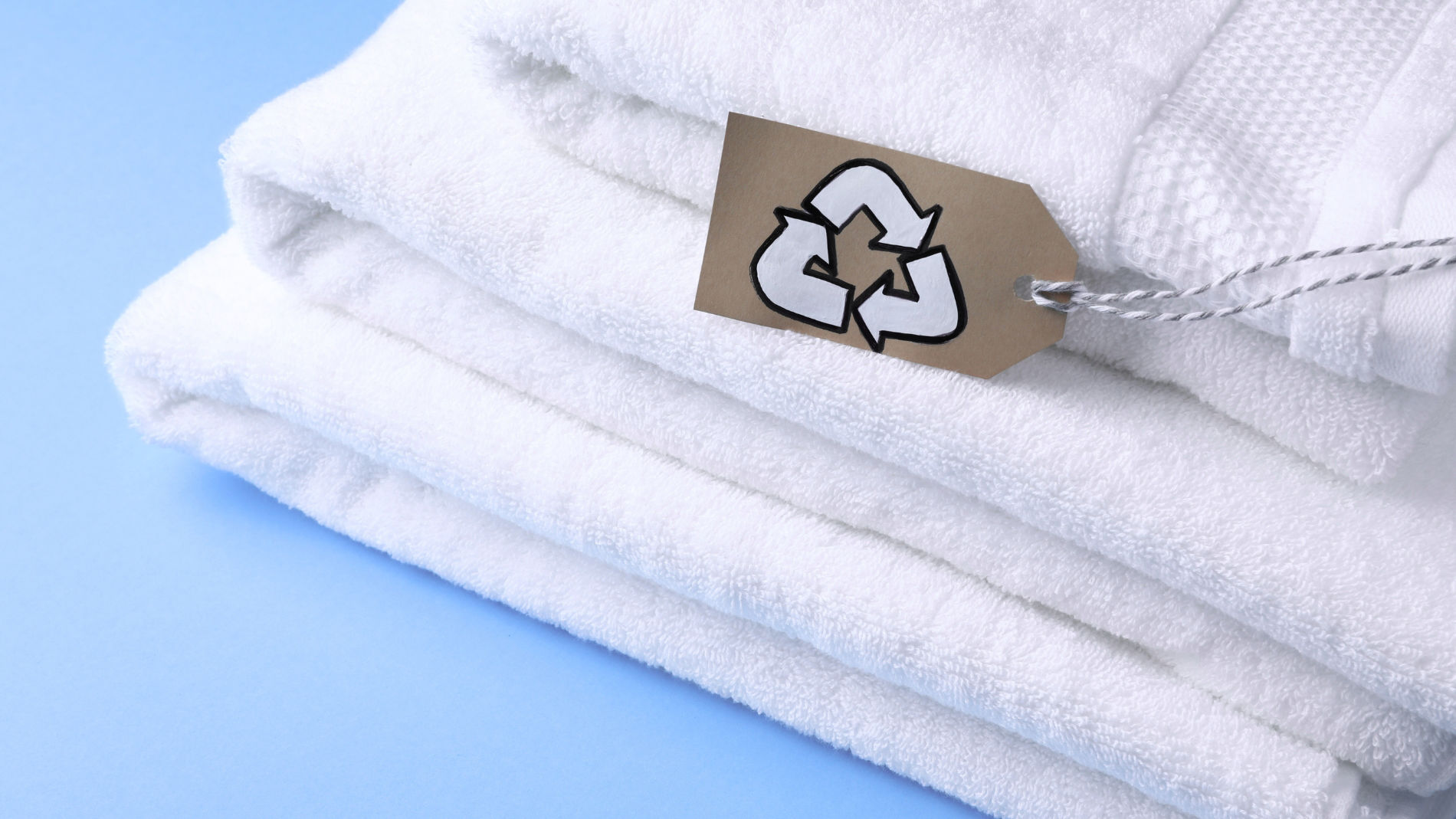 White towels with a sign showing a recycling symbol