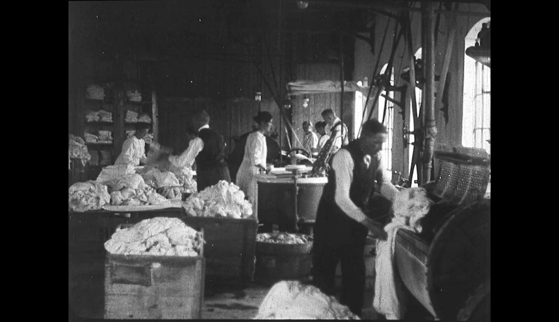 Historische Aufnahme einer Textilwäscherei mit Arbeitern und Wäschetrommeln