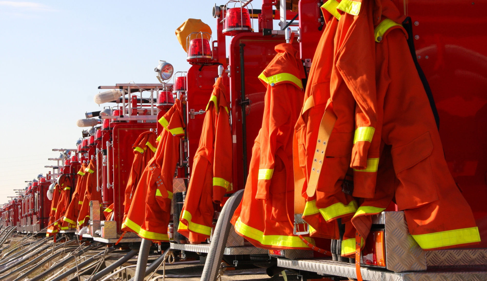 Feuerwehrschutzkleidung hängt an Einsatzfahrzeugen